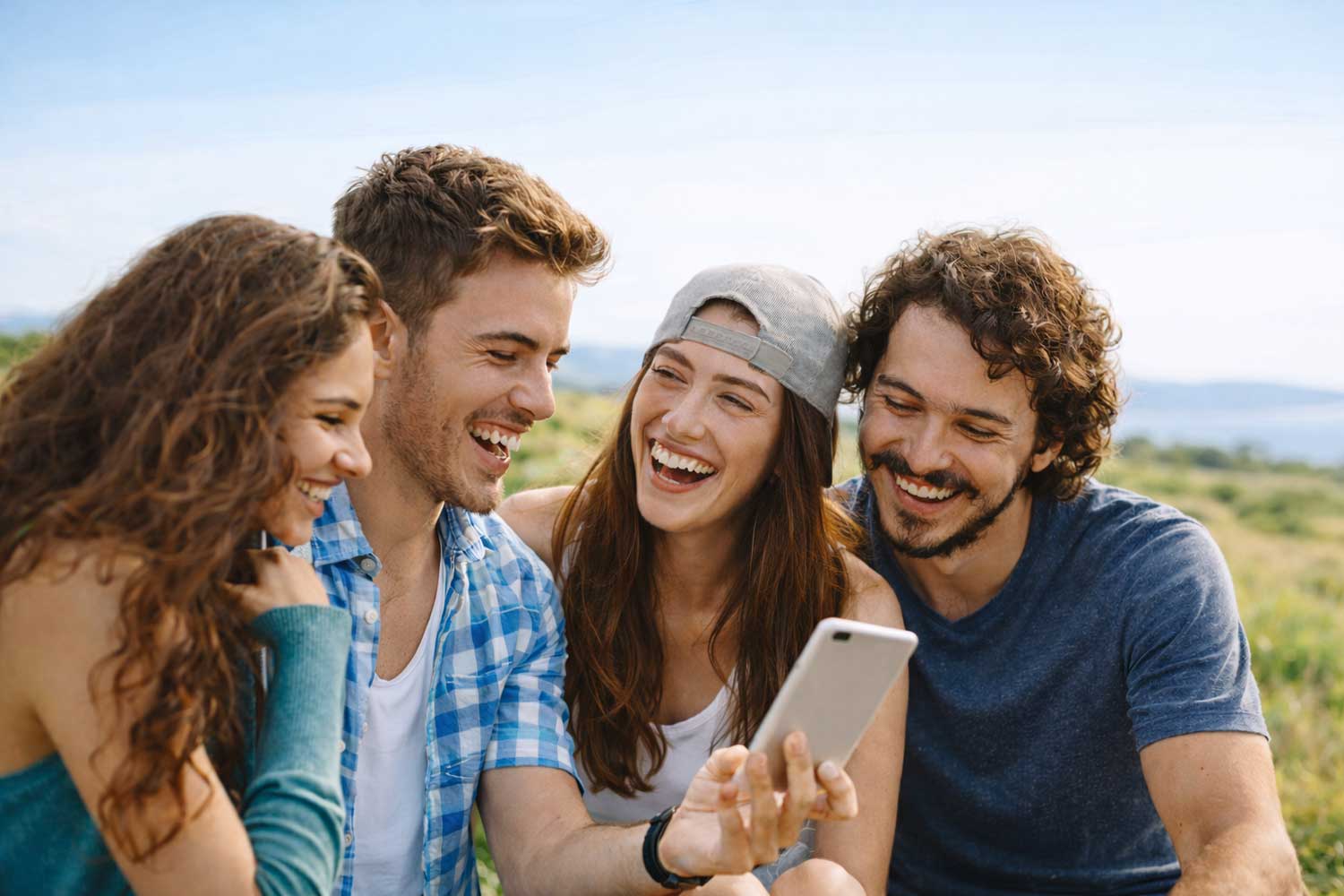 Groupe d'amis rigolant en consultant un jeu de piste interactif Enigmania